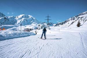 skifahrer skifahren auf schneebedeckten bergen in den alpen inmitten von richtungszeichen foto