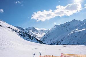 skifahrer skifahren auf schneebedeckten bergen gegen himmel foto