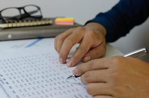 Mann Hand hält einen Stift und Dokument Papierarbeit Marketing Finanzpläne Steuern und Unternehmensinvestitionen. foto