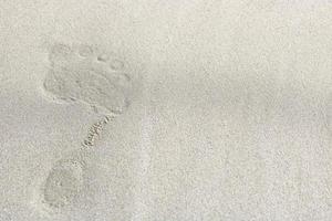 Draufsicht auf Fußspuren auf Sandhintergrund, selektiver Fokus foto