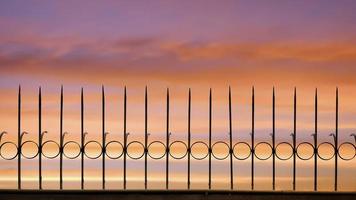 Silhouette Pfeil stacheliger Metallzaun vor schönem Sonnenuntergang Himmelshintergrund, Vorderansicht mit Kopierraum foto