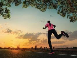 junge Frau läuft und joggt morgens ein Outdoor-Training auf der Straße für die Gesundheit des Lebensstils. foto