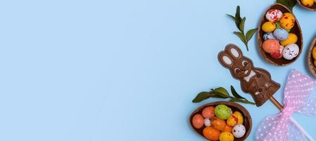 osterbanner eier jagen konzept mit schokoladenhasen auf blauem hintergrund. Ansicht von oben kopieren foto