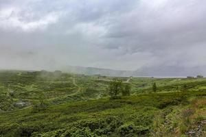 norwegen landschaft mit nebelwolken felsen klippen mit hütten hemsedal. foto