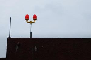 doppeltes Hindernisfeuer auf dem Dachturm an einem Tag, an dem der Himmel mit Beschneidungspfad bewölkt ist foto