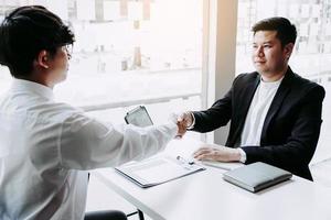 manager- und mitarbeiterinterviewkonzept mit händedruck nach gespräch über vertragsunterzeichnung. foto