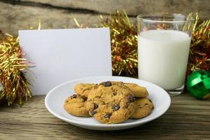 Kekse und ein Glas Milch mit einer weißen Note für Santa foto