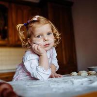 Bäckermädchen mit Kochmütze in der Küche foto