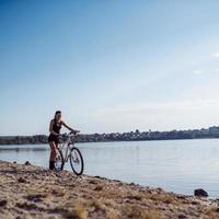 Frau auf einem Fahrrad am Strand foto