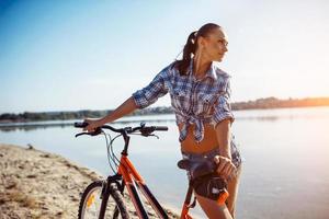 Frau auf einem Fahrrad am Strand foto