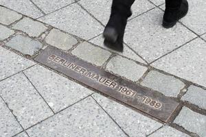 Fußgänger zu Fuß über die Gedenktafel für die Berliner Mauer foto