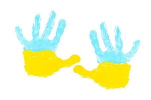 gelbe und blaue farben einer kinderhandfläche isoliert auf weiß. Konzept der ukrainischen Flaggensymbole foto