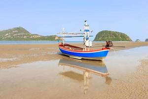 Traditionelles Fischerboot am Strand mit Reflektion