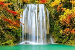 farbenfroher majestätischer wasserfall im nationalparkwald im herbst foto