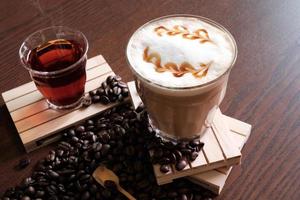 heißer kaffee und heißer tee, kaffeebohnen auf holztisch foto