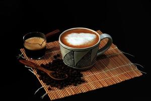 heißer latte mit kaffeebohnen auf dunklem hintergrund foto