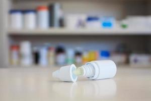 Auge Ohrentropfen Medizinflasche mit Apothekenregalen Hintergrund foto