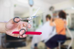 friseur hält schere mit salonschönheitshintergrund foto