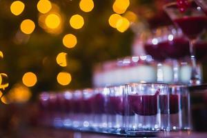 Reihe von verschiedenfarbigen Alkoholcocktails auf einer Open-Air-Party