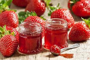 Wählen Sie frische hausgemachte Erdbeermarmelade mit Beeren in kleinen Gläsern foto