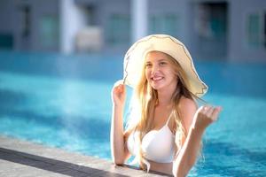 Frau im weißen Bikini am Pool bräunen foto