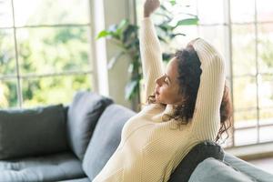 lateinische frau auf sofa mit faulheitsgefühl foto