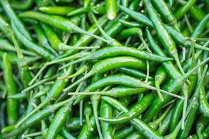 Haufen frischer grüner Chilischoten zum Verkauf auf dem Markt foto