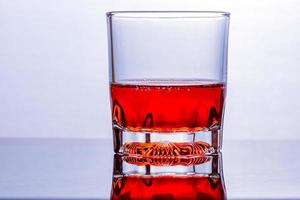 Glas Whiskey und Eis auf einem Glastisch foto