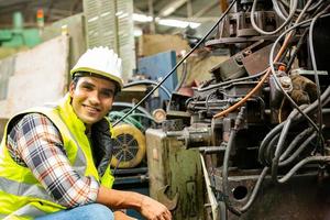 Arbeiter arbeiten auf dem Werksgelände und überprüfen die Maschine in der Produktlinie oder die Produkte vor Ort. ingenieur oder techniker, der material oder maschine in der anlage überprüft. Industrie und Fabrik. foto