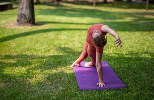 aktive schöne Blondine, die Yoga-Übungen macht und im Freien trainiert. foto