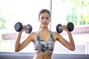 junge asiatische Frau trainiert und trainiert im Fitnessstudio.