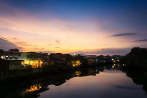 blick auf den fluss chanthaboon und die häuser am flussufer in der provinz chanthaburi bei sonnenuntergang foto