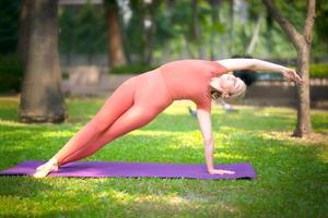 aktive schöne Blondine, die Yoga-Übungen macht und im Freien trainiert. foto