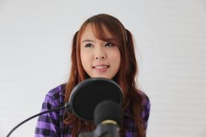 Porträt einer jungen Frau, die am Mikrofon singt, Nahaufnahme. foto