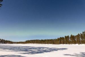 wunderschönes nordlicht alias aurora borealis und mondbeschienene winterlandschaft in finnland foto