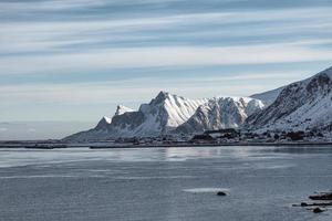 landschaft der schneebergkette mit norwegischem dorf an der küste foto