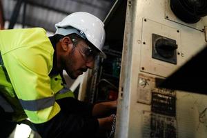 vorarbeiter oder arbeiter arbeiten am fabrikstandort und überprüfen maschine oder produkte vor ort. ingenieur oder techniker, der material oder maschine in der anlage überprüft. Industrie und Fabrik. foto