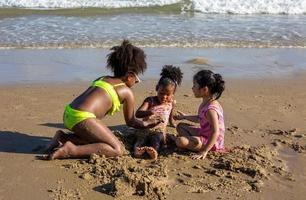 Kinder spielen auf Sand am Strand foto