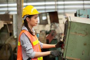 Arbeiterinnen arbeiten auf dem Werksgelände und überprüfen die Maschine in der Produktlinie oder die Produkte vor Ort. ingenieur oder techniker, der material oder maschine in der anlage überprüft. Industrie und Fabrik. foto