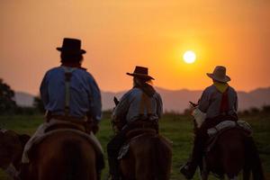 Silhouette Cowboy zu Pferd vor einem wunderschönen Sonnenuntergang, Cowboy und Pferd im ersten Licht, Berg, Fluss und Lebensstil mit natürlichem Lichthintergrund foto