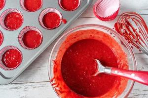 roter samtkuchenteig mit zutaten und cupcake-dose flach liegend foto