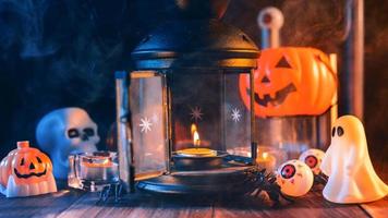 halloween-feiertagskonzeptdesign von kürbis, kerze, gruseligen dekorationen mit grüntonrauch herum auf einem dunklen holztisch, nahaufnahme.