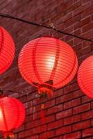 Schöne runde rote Laterne, die an der alten traditionellen Straße hängt, Konzept des chinesischen Neujahrsfests, Nahaufnahme. Das untere Wort bedeutet Segen. foto