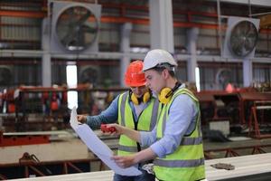 industriearbeiter vorarbeiter oder arbeiter arbeiten am fabrikstandort und überprüfen maschine oder produkte vor ort. ingenieur oder techniker, der material oder maschine in der anlage überprüft. Industrie und Fabrik. foto