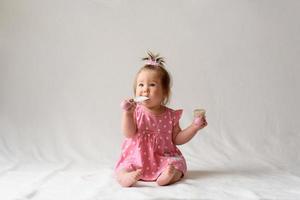 kleines Mädchen 6 Monate alt mit einem Kamm in der Hand auf weißem Hintergrund. foto