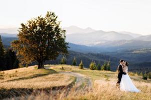 schöne braut und bräutigam in den bergen foto