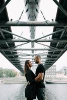 Junges verliebtes Paar, das auf der Berghängebrücke steht und sich lächelnd ansieht foto