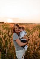 Eine Mutter geht mit ihrer kleinen Tochter im Arm über das Feld. foto