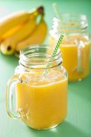 gesunder gelber Smoothie mit Mango-Ananas-Banane im Einmachglas