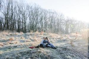 sinnliches paar der jungen hübschen mode in der liebe, die im kalten winterfeld sitzt foto